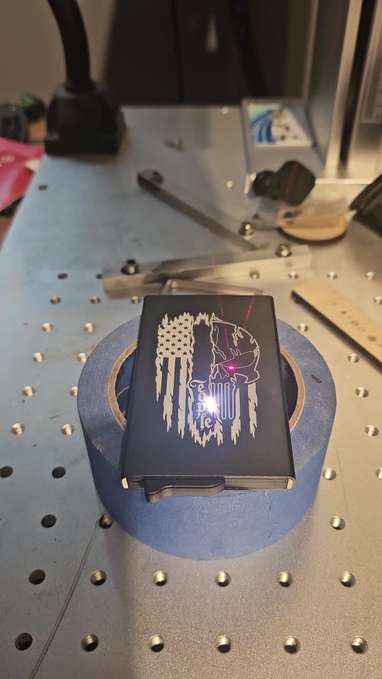 Laser engraving in progress on a small metal accessory